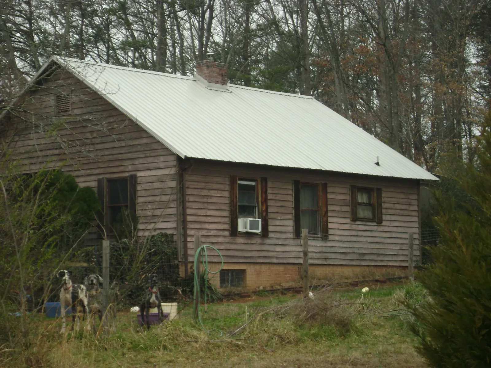 White metal roof on an old wood sided farmhouse, from a Metal Roof Installation job in Logan